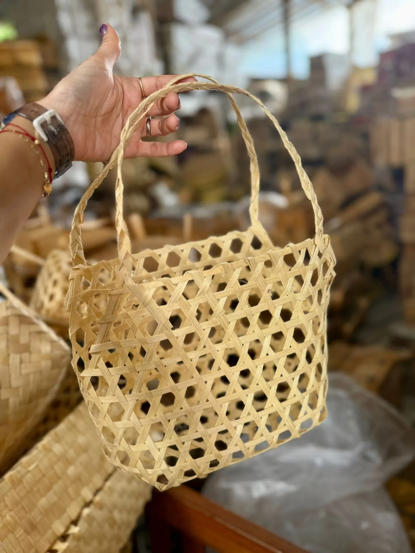 A hand holding a small woven besek basket