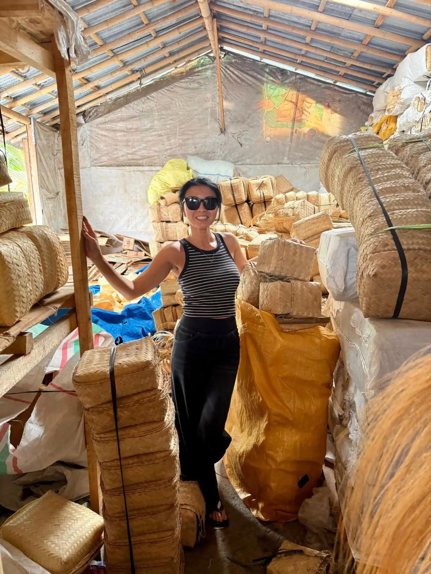 Inside the besek warehouse with stacks of woven bamboo