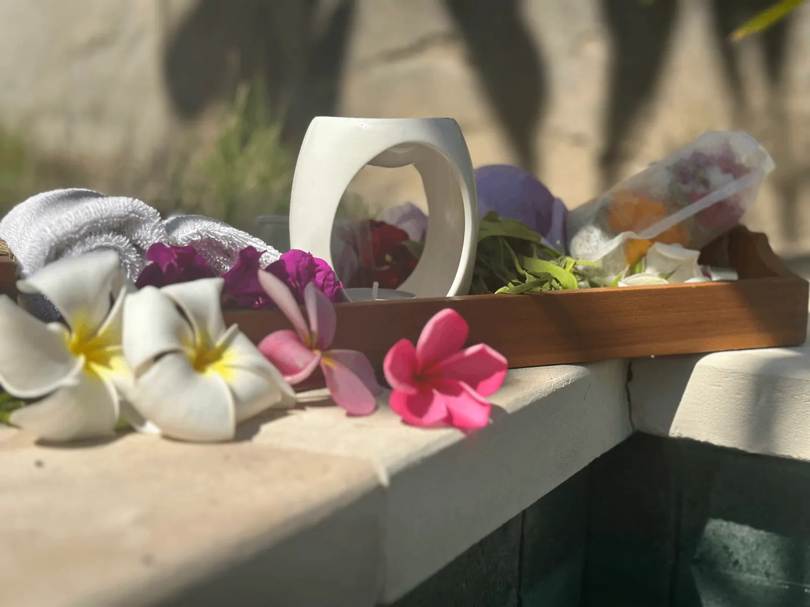 Flowers and ceramic burner arranged on wooden tray