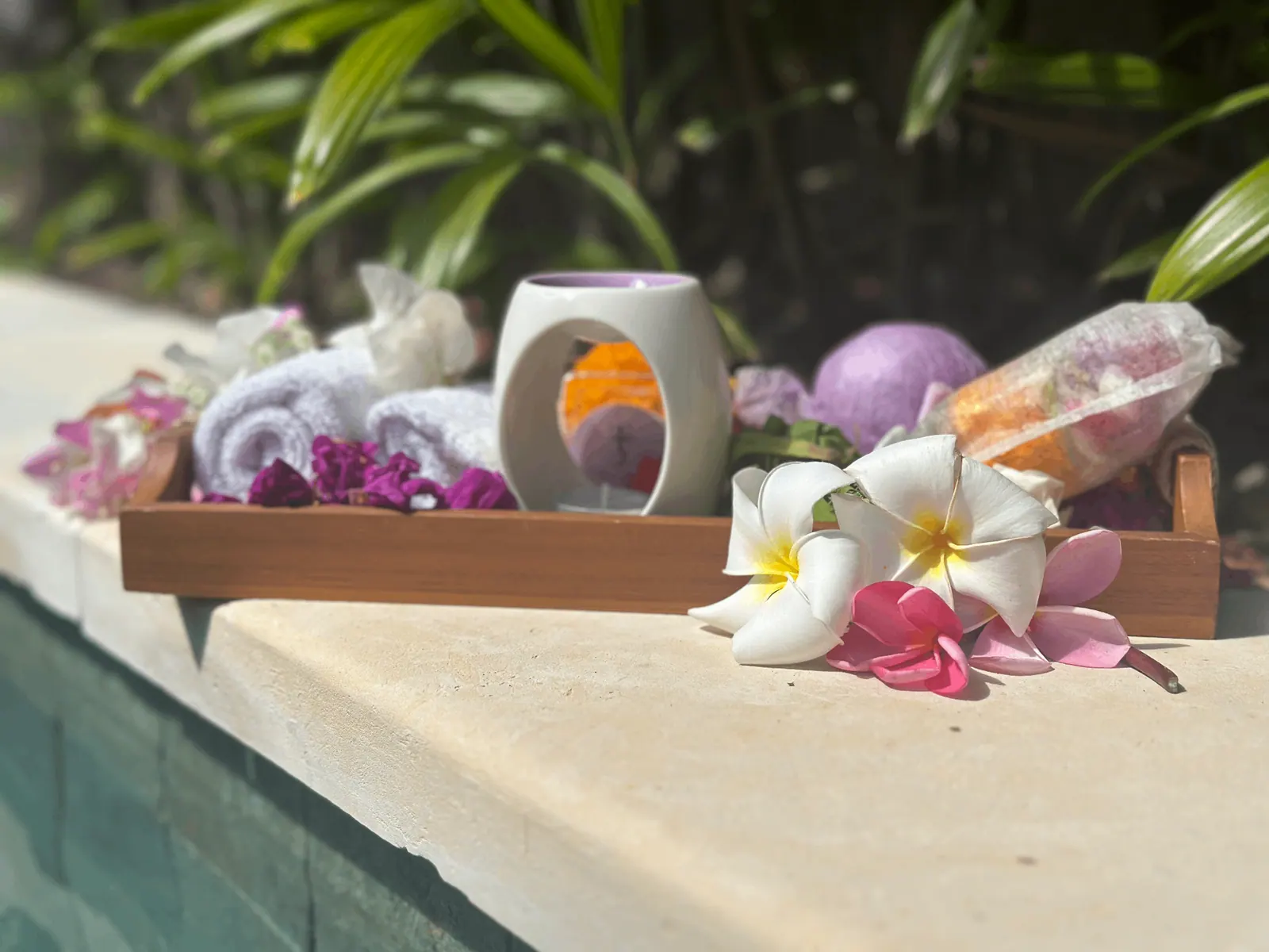 Mandi7 product setup by the pool with frangipani flowers
