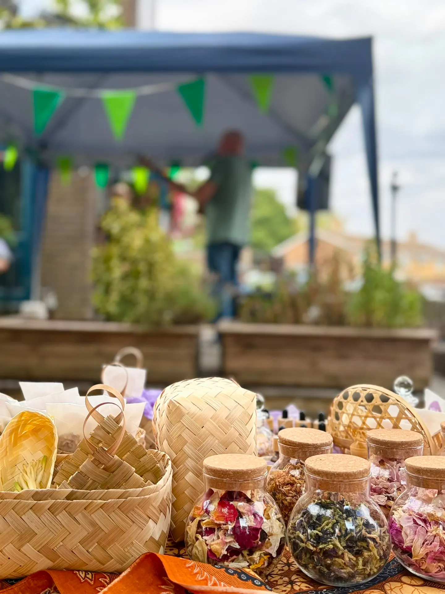 Glass jars of dried flowers on the Mandi7 table with the market stage behind